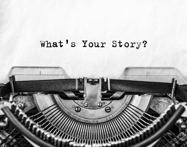 Vintage typewriter with a sheet of paper displaying the text "What's Your Story?" in bold, typewriter font.
